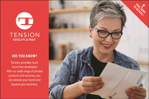 A smiling woman with short gray hair and glasses looks at Peel and Reveal postcard. Next to her is a red panel with the Tension Envelope & Print logo and info about their printed products and services.